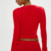 Red long-sleeve top worn by a person - back view